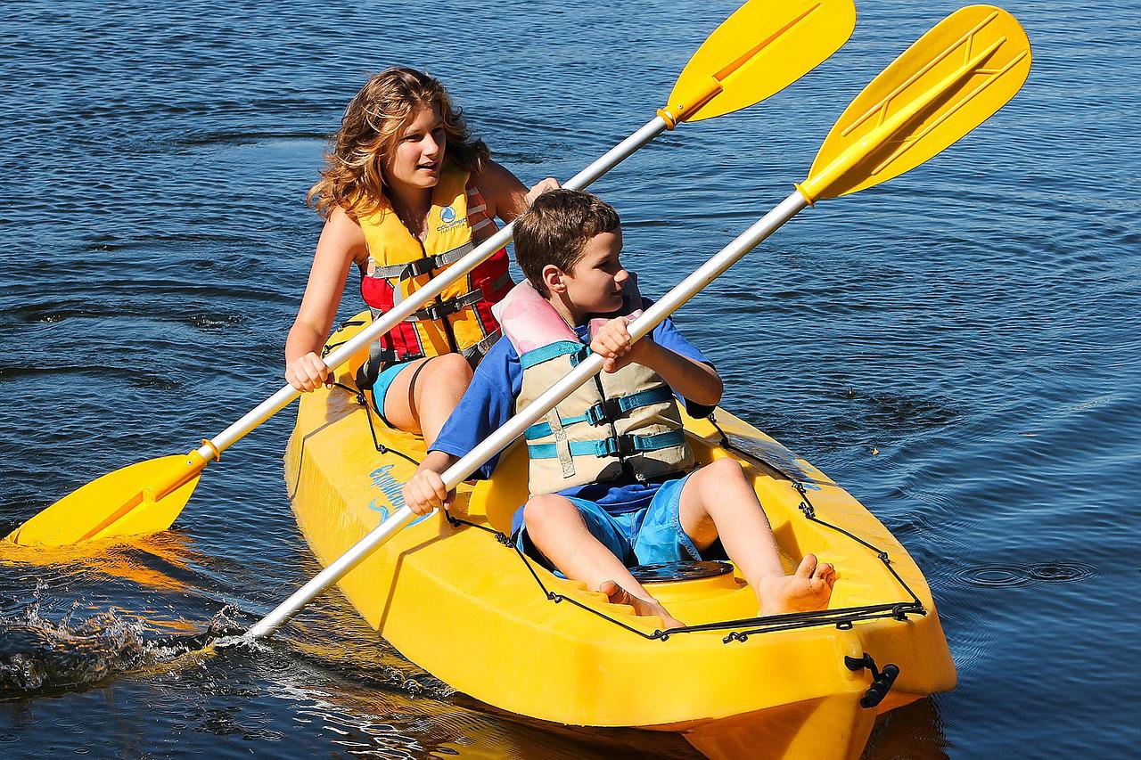 Two children kayaking in a lake