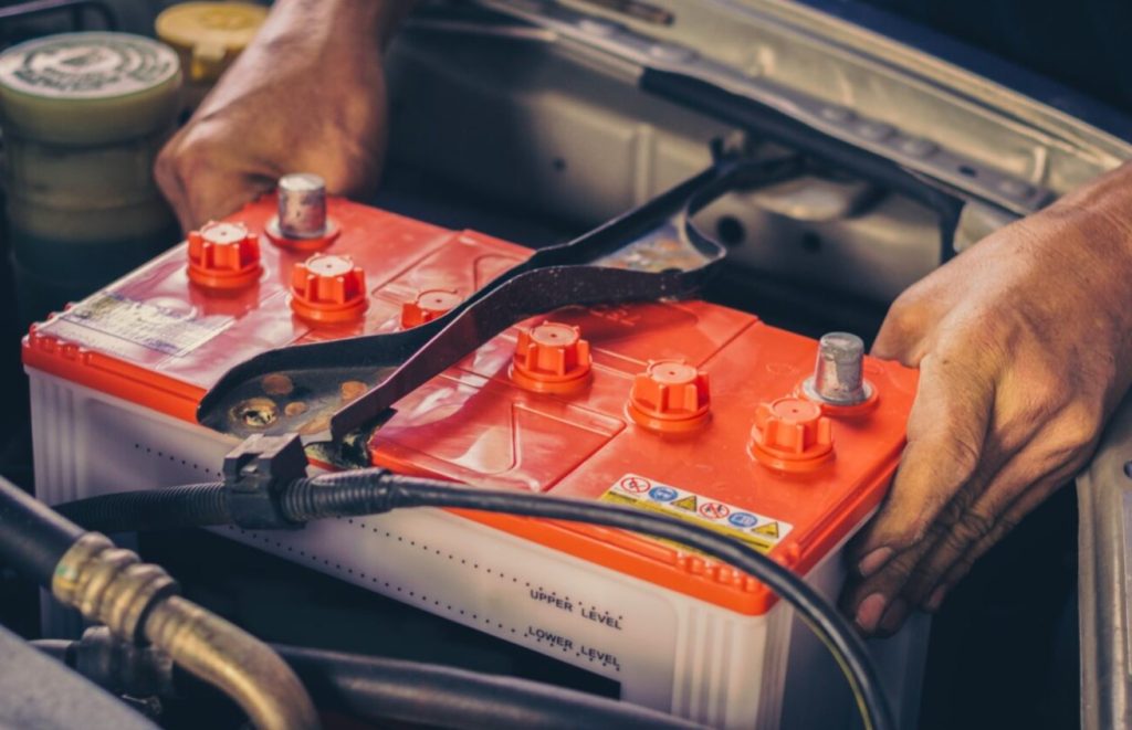 a Chevrolet technician fixing up a vehicle battery.